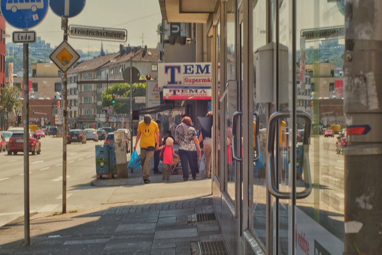 street, building exterior, text, built structure, transportation, architecture, road, communication, city, non-western script, car, roadside, store, city street, information sign, retail, city life, day, outdoors