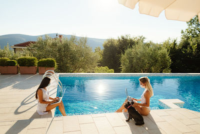 Rear view of woman sitting in swimming pool