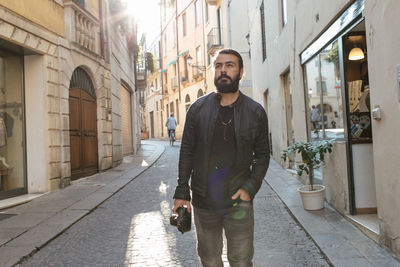 Man standing on street amidst buildings
