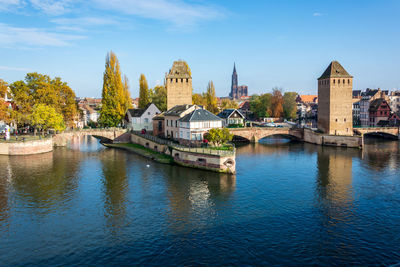 Arch bridge over river against buildings in city