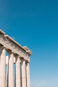 Low angle view of acropolis against clear sky during sunny day