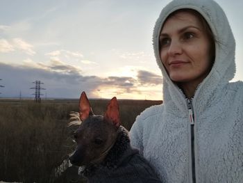 Portrait of young woman with horse against sky