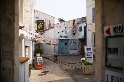 Signs in alley amidst buildings