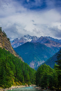 Scenic view of river and mountains against cloudy sky