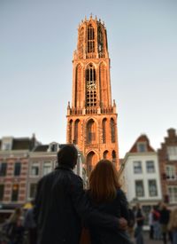 Rear view of people standing in front of building