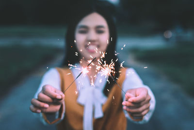 Close-up of woman holding sparkler