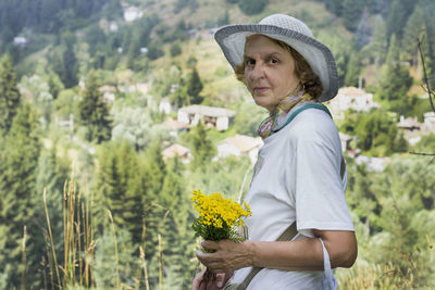 Full length of woman standing by flowering plants