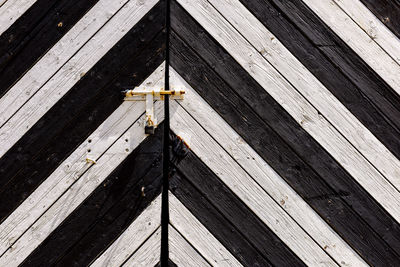 Detail of old wooden gates, doors with cracked paint. black and white old wooden planks