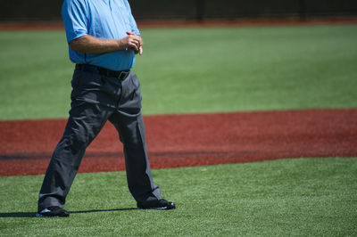 Low section of referee standing on playing field