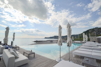 Panoramic view of swimming pool by sea against sky