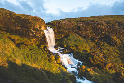 Scenic view of waterfall against sky