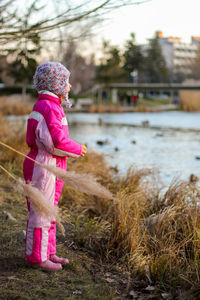 Girl with pink umbrella standing in water