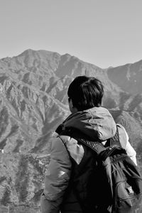 Rear view of man with backpack against mountain