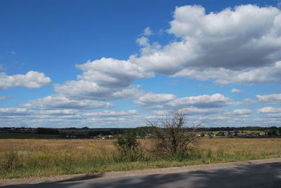 Road amidst field against sky