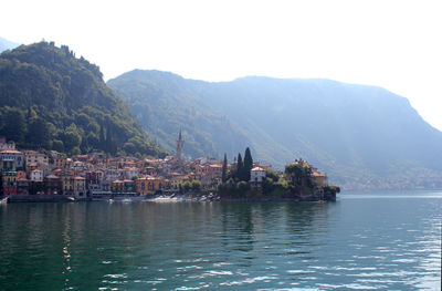Scenic view of lake by buildings against sky