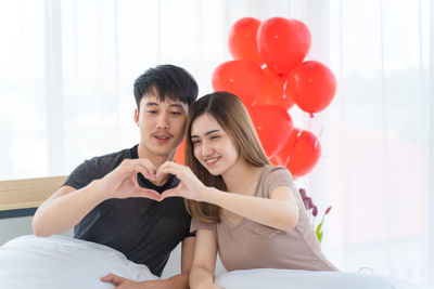 Young couple sitting on balloons