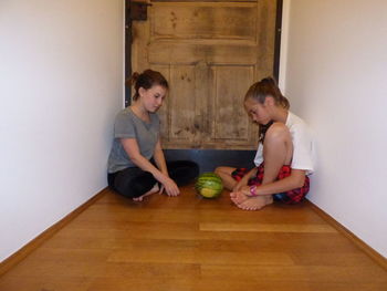 Young woman sitting on wooden floor