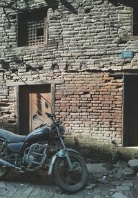 Bicycle leaning against brick wall
