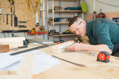 Side view of young woman working at workshop