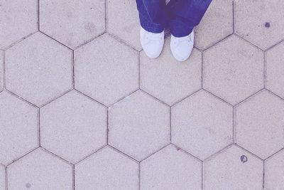 Low section of person standing on tiled floor