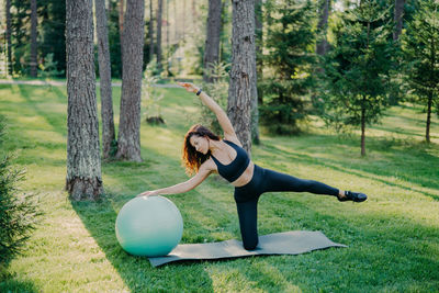 High angle view of woman with fitness ball exercising in park