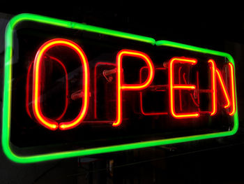 Open neon sign in shop or store window at night