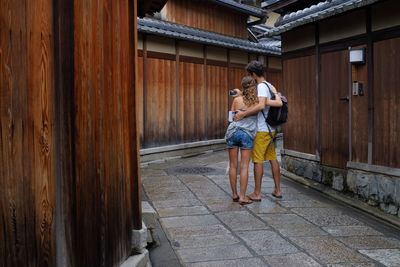 Rear view of woman standing in front of wooden walkway