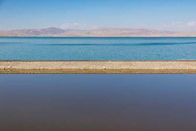 Scenic view of railroad track amidst sea against sky