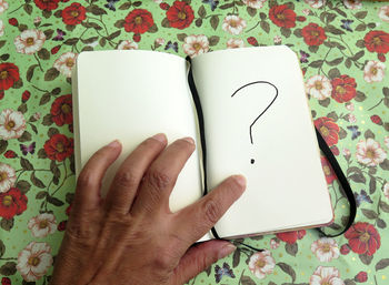 Midsection of person holding book on table