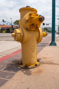 Yellow fire hydrant on footpath in city