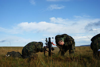 Soldiers on field against sky