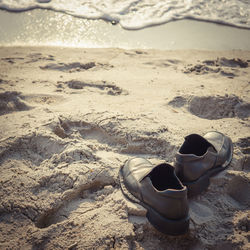 High angle view of shoes on sand at beach