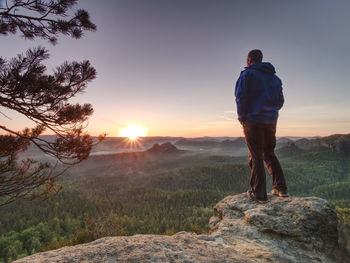 Tall man in sports clothes enjoy morning view into pure nature landscape. guy clear his soul.