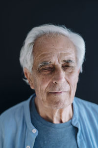 Portrait of mature man against black background