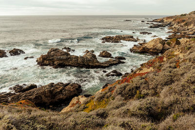 Scenic view of rocks on beach against sky