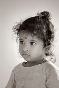 Portrait of cute girl looking away against white background