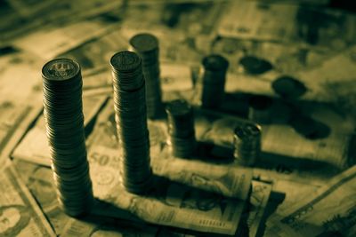 Stack of coins and paper currency on table