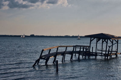 Pier over sea against sky during sunset