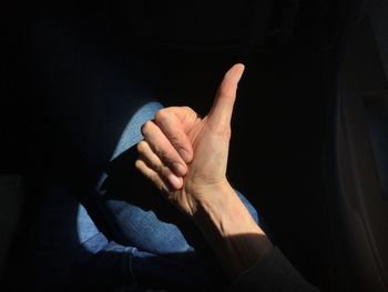 Cropped image of hand showing thumbs up in airplane