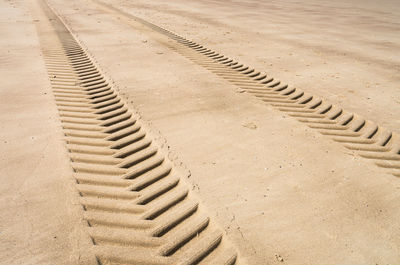 High angle view of tire tracks on sand