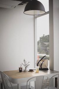 Pendant light hanging over table by window at home