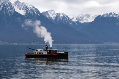 Scenic view of sea and snowcapped mountains against sky