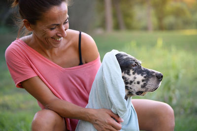 Side view of woman with dog on field