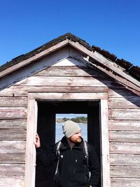 Woman standing on wooden wall
