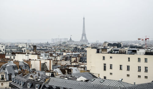 Aerial view of buildings in city against clear sky