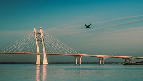 View of suspension bridge over sea against sky