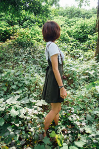 Rear view of woman standing by tree