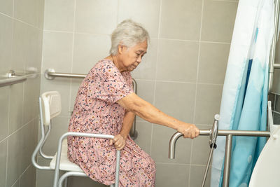 Side view of man washing hands in bathroom