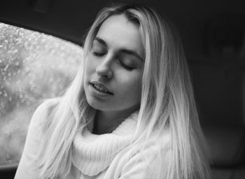 Close-up of young woman with eyes closed sitting in car