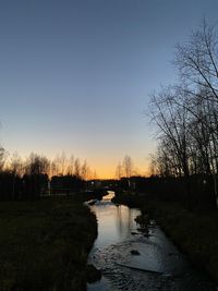 Scenic view of lake against clear sky during sunset